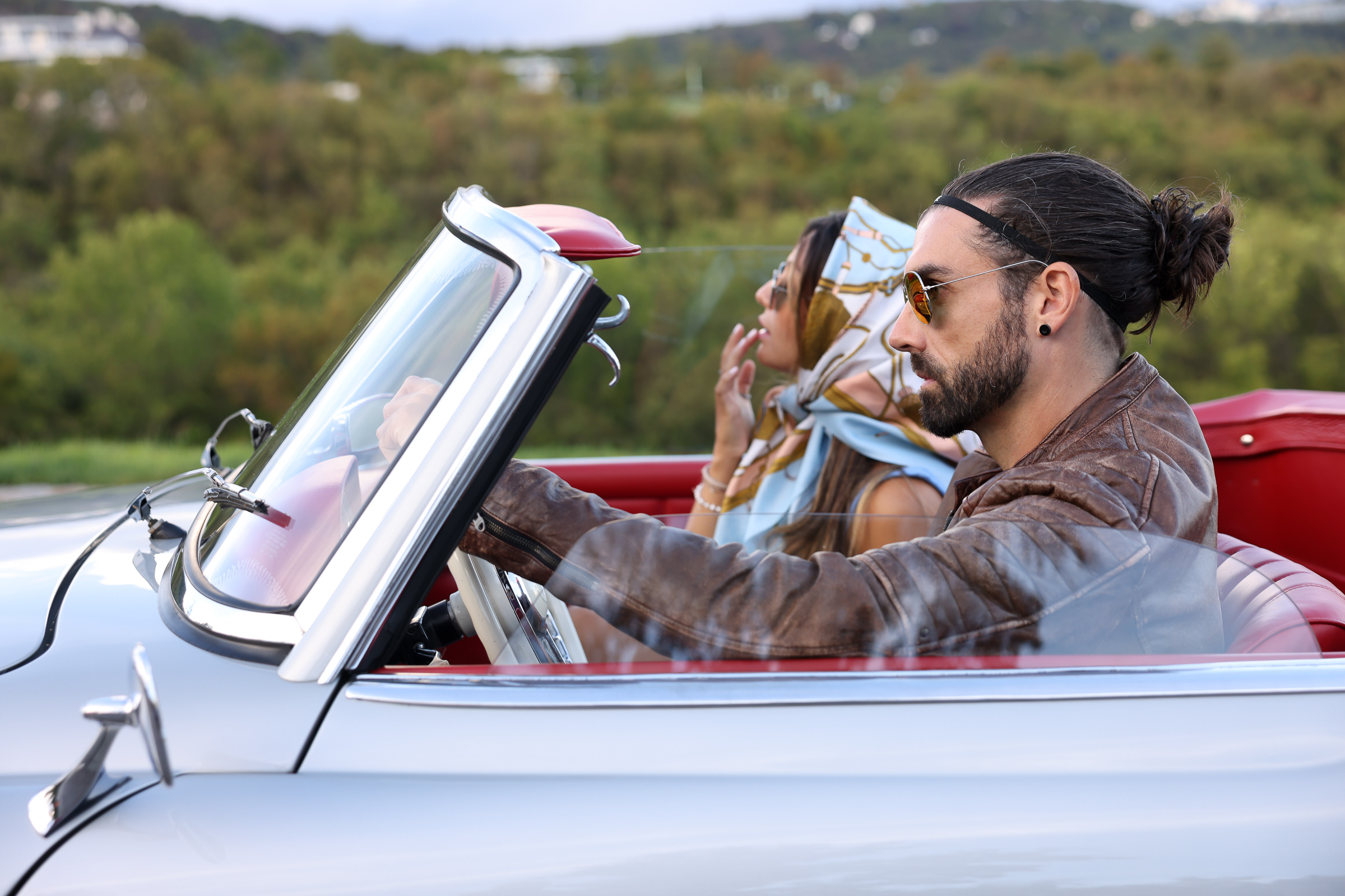 Mann mit gepflegtem Bart am Steuer eines Autos mit einen Frau als Beifahrerin