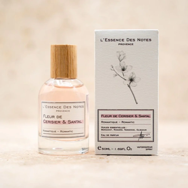 Flakon des Fleur de Cerisier & Santal Parfüms neben seiner eleganten Verpackung.