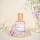 Eau de Parfum Fleur de Cerisier & Santal, stilvoll präsentiert auf einem pastellfarbenen Hintergrund mit Blumen.