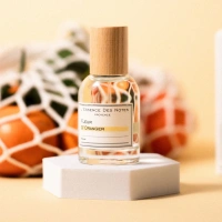 Fleur dOranger Eau de Parfum: Parfümflakon auf einem kleinen Podest im Hintergrund ein Netz mit Orangen